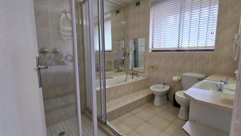 Large ensuite bathroom with walk-in shower and a bath off of the main bedroom in C Front 11 self-catering penthouse.