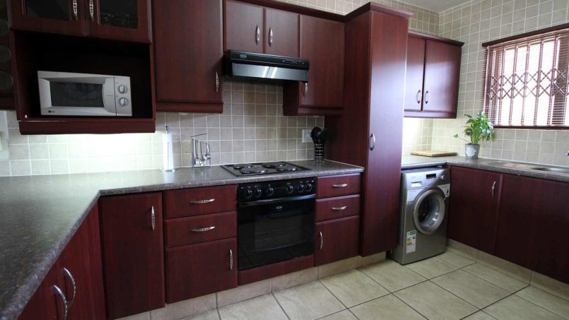 Fully equipped kitchen with stove, microwave, and fridge at Le Touessrok 32