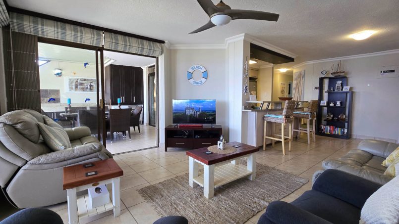 Open plan lounge leads onto kitchen and patio with sea view at Chardonnay Cabanas 5