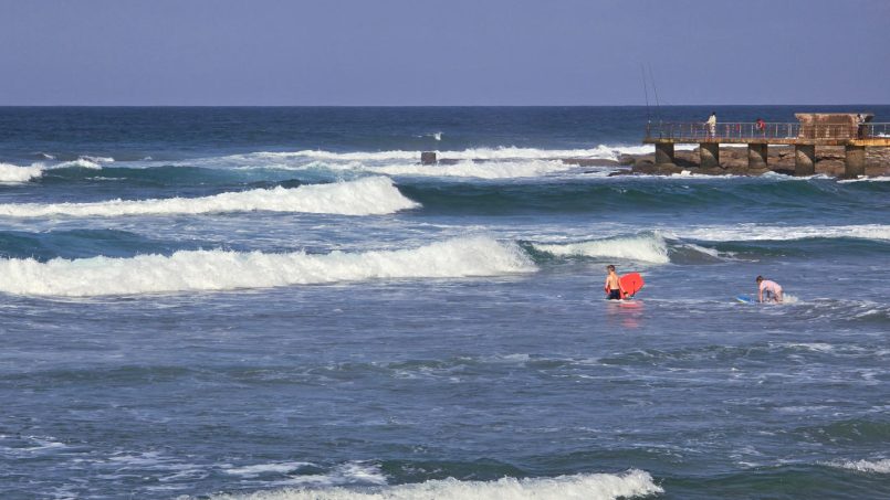 Children body-boarding at Uvongo Beach, just steps from Topanga 25 – a beachfront holiday rental in Uvongo ideal for families looking for fun in the surf.