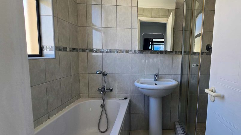 En suite bathroom with bath and shower combination at Margate Sun 11, a family holiday apartment near Margate Pier.